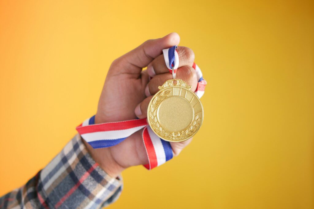 Hand holding a Gold Medal