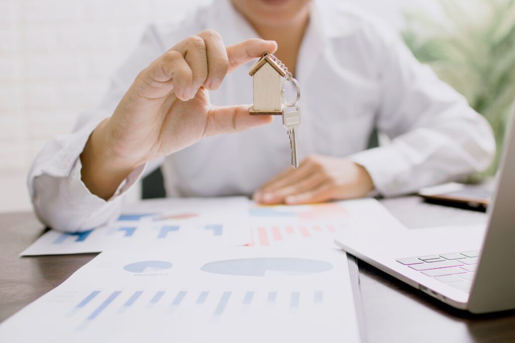 Property manager showing off golden keychain and property marketing results on paper on their desk