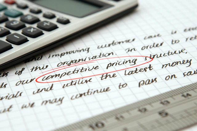 a calculator on top of a paper with the words "competitive pricing" circled in red